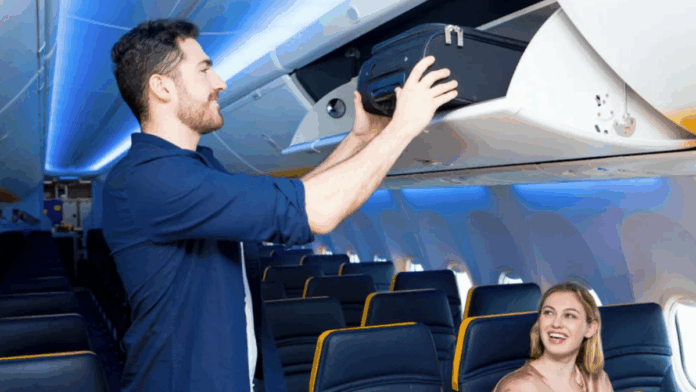 Homem guardando mala de mão no bagageiro do avião