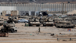 Foto panorâmica em Gaza; tanques e soldados do exército de Israel passam pela área