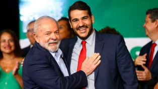 Lula e Messias abraços e sorrindo. Lula com mão no peito de Messias