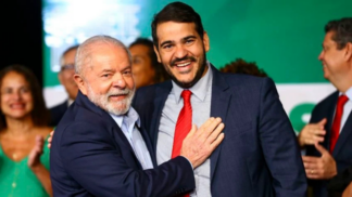 Lula e Messias abraços e sorrindo. Lula com mão no peito de Messias