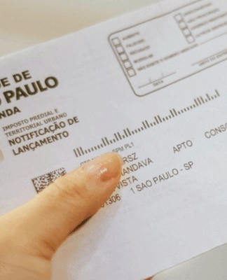 boleto de iptu de são paulo sendo segurando por uma pessoa