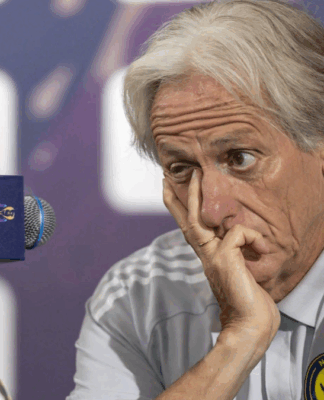 Técnico Jorge Jesus em coletiva de imprensa com expressão de irritação