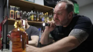 Policial aponta lanterna para uma bebida alcoólica