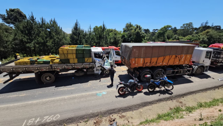 Caminhões e carros do acidente parados na estrada