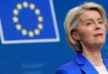 A presidente da União Europeia aparece à frente da bandeira da entidade