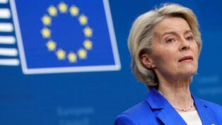 A presidente da União Europeia aparece à frente da bandeira da entidade