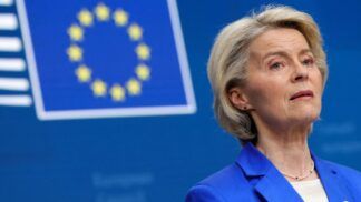 A presidente da União Europeia aparece à frente da bandeira da entidade