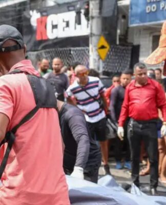 Homens carregam caixa com corpo até um carro