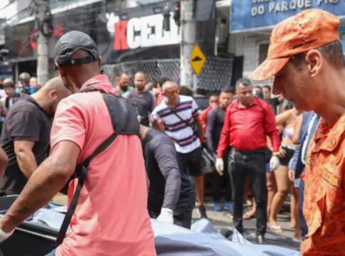 Homens carregam caixa com corpo até um carro