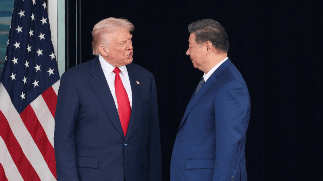 Donald Trump e Xi Jinping se olham ao lado da bandeira dos EUA