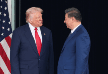 Donald Trump e Xi Jinping se olham ao lado da bandeira dos EUA
