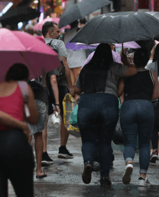 Pessoas em São Paulo andando sob um guarda-chuva em dia chuvoso na capital