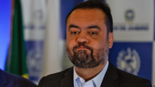 Plano aberto mostra o governador do Rio de Janeiro, Cláudio Castro, e logo atrás, olhando pra ele, o ministro da Justiça e Segurança Pública, Ricardo Lewandowski