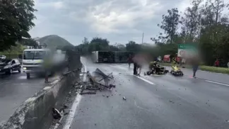 Ônibus deitado na pista e destroços sobre o asfalto