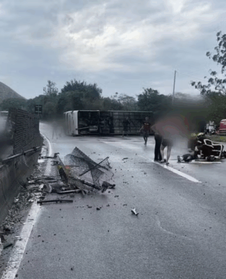 Ônibus deitado na pista e destroços sobre o asfalto
