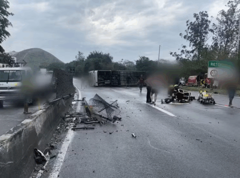 Ônibus deitado na pista e destroços sobre o asfalto