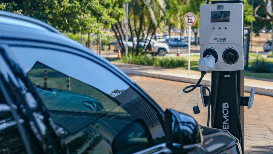 Carro elétrico parado num ponto de recarga enquanto é reabastecido