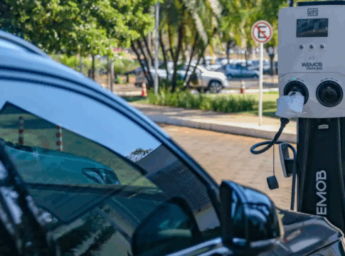 Carro elétrico parado num ponto de recarga enquanto é reabastecido