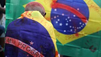 Criança com bandeira do Brasil manchada de sangue após operação no Rio de Janeiro