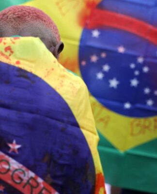Criança com bandeira do Brasil manchada de sangue após operação no Rio de Janeiro