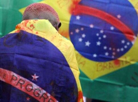 Criança com bandeira do Brasil manchada de sangue após operação no Rio de Janeiro