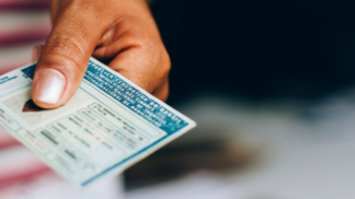 Mão de uma pessoa negra segurando uma CNH