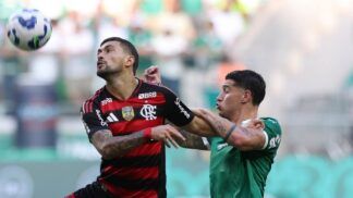 O jogador Emiliano Martínez, do Palmeiras, disputa bola com Arrascaeta do Flamengo