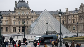 Entrada principal do Museu do Louvre, em Paris, com carro de polícia parado na frente