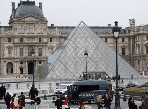 Entrada principal do Museu do Louvre, em Paris, com carro de polícia parado na frente