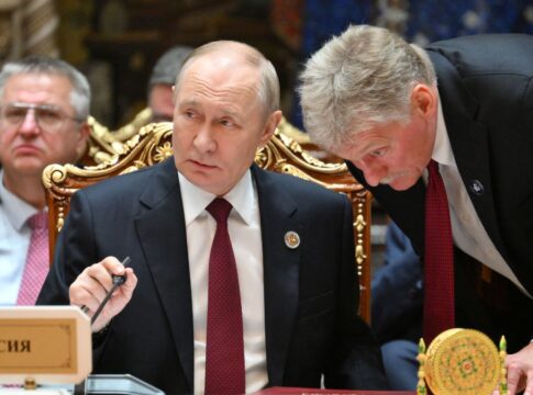 Porta-voz russo, Dmitry Peskov, fala ao ouvido do presidente Vladimir Putin