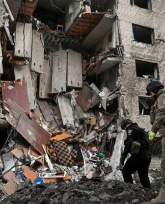 Soldados ucranianos inspecionam destroços de um prédio vitimado pelo bombardeio russo