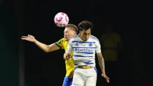 O zagueiro do Palmeiras disputa a bola no ar com o atacante do Cruzeiro durante partida entre as equipes