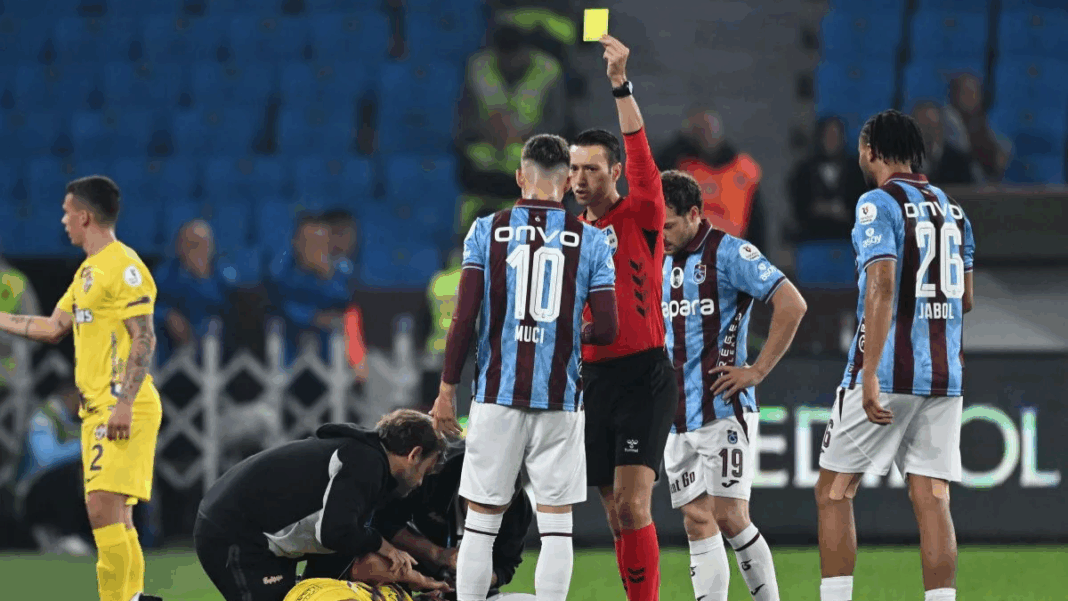 Árbitro aplicando o cartão amarelo durante partida do Campeonato Turco