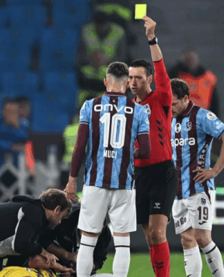 Árbitro aplicando o cartão amarelo durante partida do Campeonato Turco