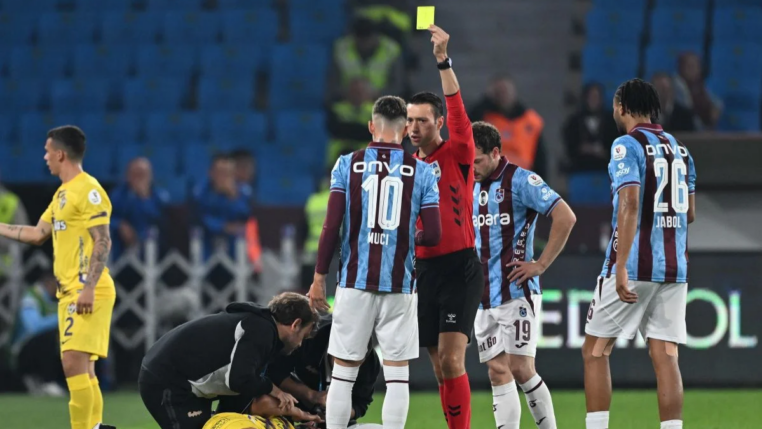 Árbitro aplicando o cartão amarelo durante partida do Campeonato Turco