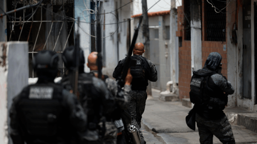 Foto tirada logo atrás de policiais durante ação em uma favela