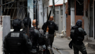 Foto tirada logo atrás de policiais durante ação em uma favela