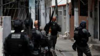 Foto tirada logo atrás de policiais durante ação em uma favela