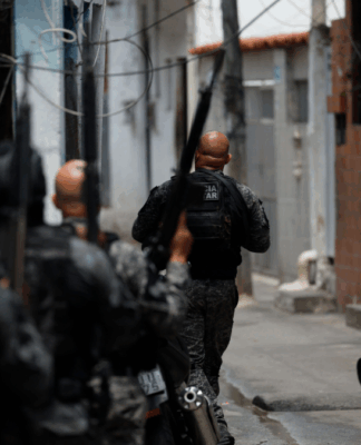 Foto tirada logo atrás de policiais durante ação em uma favela