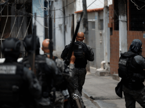 Foto tirada logo atrás de policiais durante ação em uma favela