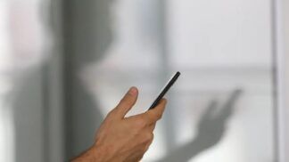 Imagem colorida de pessoa segurando o celular