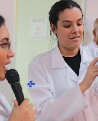 Dentistas do SUS fazendo uma apresentação com uma boca de brinquedo gigante