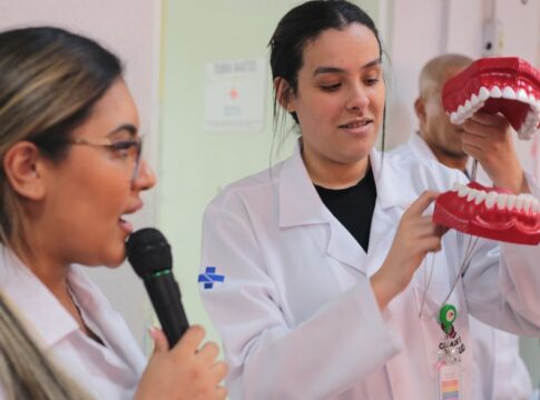 Dentistas do SUS fazendo uma apresentação com uma boca de brinquedo gigante