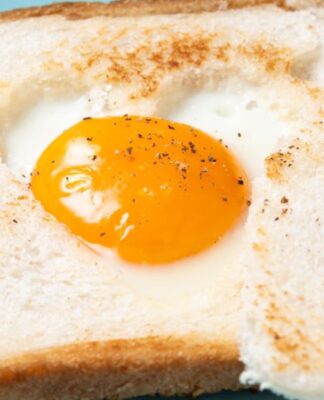 Pão de forma com um ovo encima com a gema meio mole