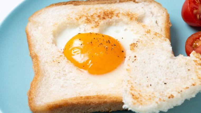 Pão de forma com um ovo encima com a gema meio mole