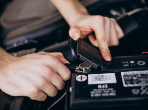 Homem arrumando a bateria do carro