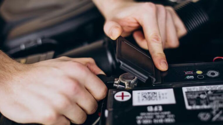 Homem arrumando a bateria do carro