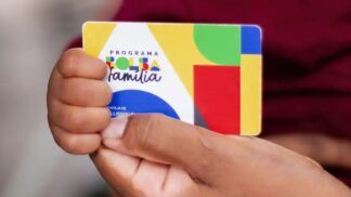Pessoa segurando o cartão do Bolsa Família