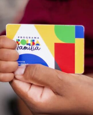 Pessoa segurando o cartão do Bolsa Família