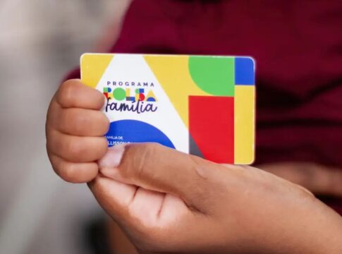 Pessoa segurando o cartão do Bolsa Família
